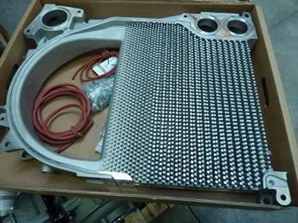 Remeha-Zwischenglied mit metallischer Oberfläche und Anschlussmöglichkeiten, abgelegt in einer Kartonverpackung.